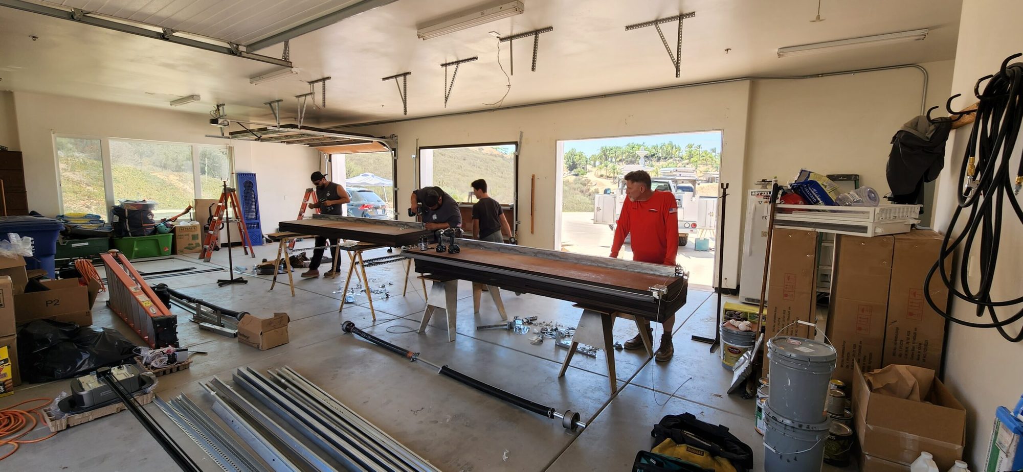 Glen's Garage Doors crew in the workshop with door parts and hardware